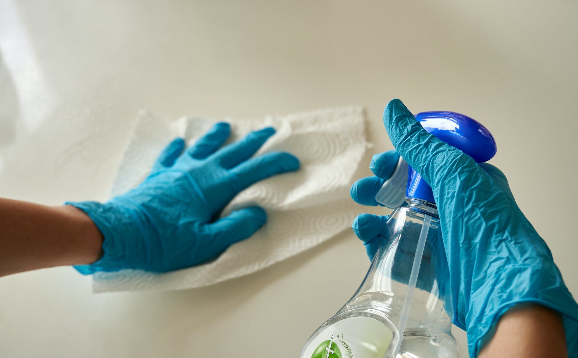 Hands with Gloves Holding a Spray Bottle
