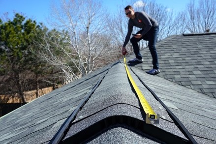 a man measuring a roof with a tool