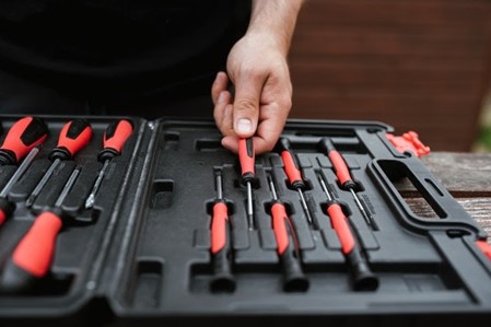A person taking a screwdriver out of a toolbox