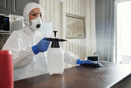 Professional cleaner cleaning a surface in safety equipment