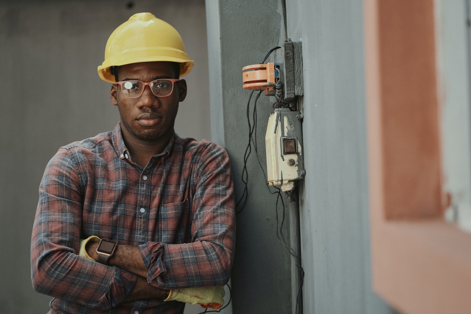 A building maintenance worker stands next to a wall.