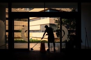 A person deep cleaning the entrance of a commercial office building
