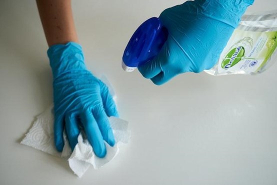 Person wearing blue gloves and cleaning.