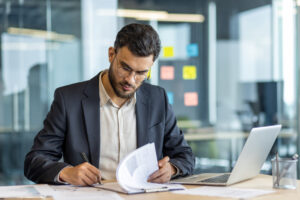 Operations manager reviewing facility vendor contracts at a desk