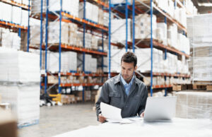 Facility manager reviewing a preventive maintenance schedule on a tablet in a large commercial building